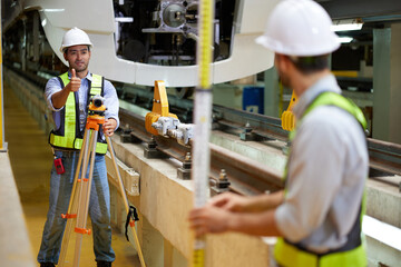 worker or engineer using theodolite surveying optical instrument for measuring at construction...