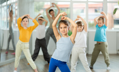 Fototapeta premium Group of boys and girls rehearsing modern dance in studio