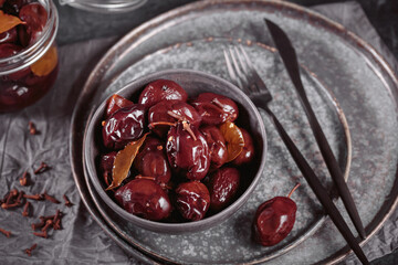 Preserving pickled plums in its own juice and seasonings on a wooden table. Healthy fermented food. Home canned vegetables.