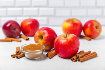 Apples with cinnamon on a textured wooden background. Fragrant red spiced apples with cinnamon sticks and star anise. Apple slices with spicy spices. Place for text. Copy space. Harvesting. Fruits.