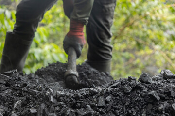 miner working with shovel on rocks taken out of the mine 