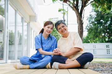 Obraz premium Nurse in a blue uniform is sitting on the ground with a woman in a yellow shirt.