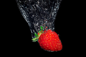 strawberry splashing into water on black background, underwater shot