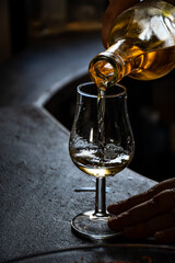 Tasting of cognac spirit aged in old dark French oak barrels in cellar distillery house, Cognac white wine region, Charente, Segonzac, Grand Champagne, France