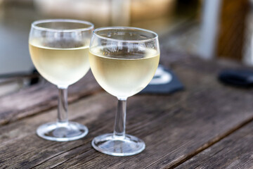 Tasting of Bordeaux white wine, right bank of Gironde Estuary, France. Glasses of white sweet French wine served in outdoor restaurant