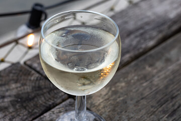 Tasting of Bordeaux white wine, right bank of Gironde Estuary, France. Glasses of white sweet French wine served in outdoor restaurant