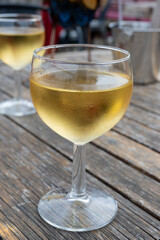 Tasting of Bordeaux white wine in Sauternes, left bank of Gironde Estuary, France. Glasses of white sweet French wine served in outdoor restaurant