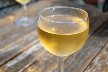 Tasting of Bordeaux white wine in Sauternes, left bank of Gironde Estuary, France. Glasses of white sweet French wine served in outdoor restaurant