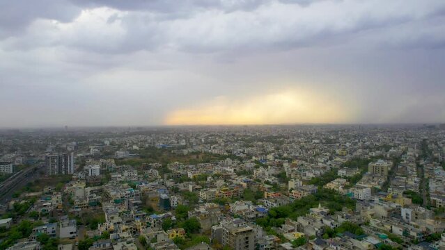 side panning aerial drone shot showing densely populated buildings houses offices cityscape of jaipur with monsoon clouds overhead showing this serene peaceful city