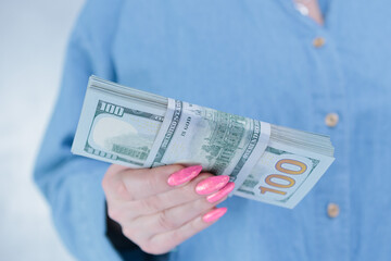female hands holding American dollar paper bills