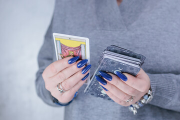Female hands holding tarot cards for fortune telling and tricks