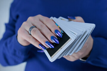 Female hands holding tarot cards for fortune telling and tricks
