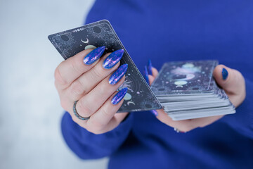Female hands holding tarot cards for fortune telling and tricks