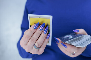 Female hands holding tarot cards for fortune telling and tricks