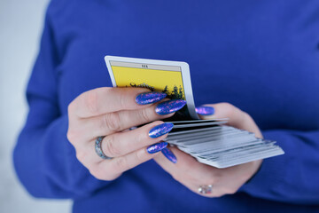 Female hands holding tarot cards for fortune telling and tricks