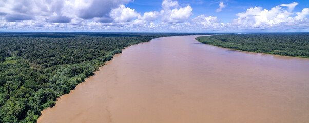 Obraz premium Beautiful aerial view of Amazon rainforest, the largest tropical forest in the world. Madeira river water and forest trees landscape at summer dusk. Concept of nature, environment, ecology, climate.