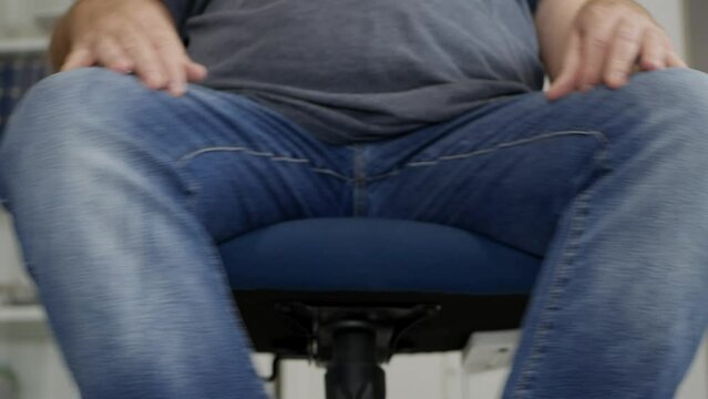 Blurred Shooting with a Person Rotating Around with an Office Chair in the Office. Businessman Sitting on a Chair in the Office.