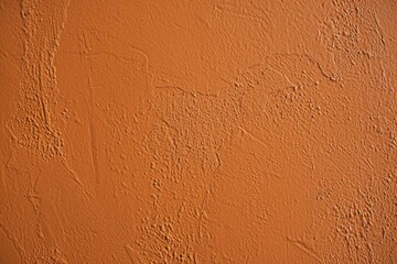 Rough orange wall texture background with brush strokes and imperfections. Providing a grunge and rustic aesthetic. The textured surface adds depth and character. Suitable for various design projects