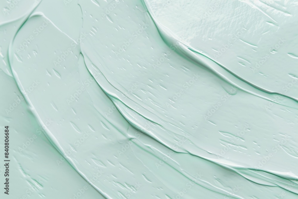 Poster light green cosmetic cream is smeared creating a wavy texture that could be used as a background for
