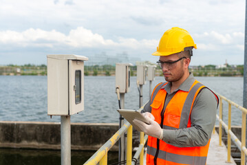 an engineer looking at the valve gauge plumbing system and type it down on a tablet to check the...