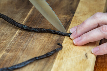 A vanilla pod being sliced to obtain the seeds for baking