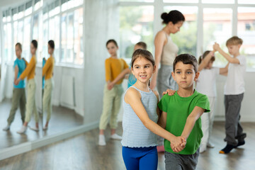 Couple boy and girl rehearsing pair waltz dance in studio