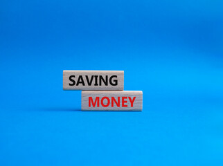 Saving Money symbol. Concept word Saving Money on wooden blocks. Beautiful blue background. Business and Saving Money concept. Copy space