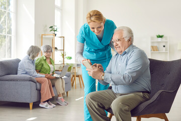 Positive caring kind smiling nurse, geriatric medicine caretaker providing senior man help with...