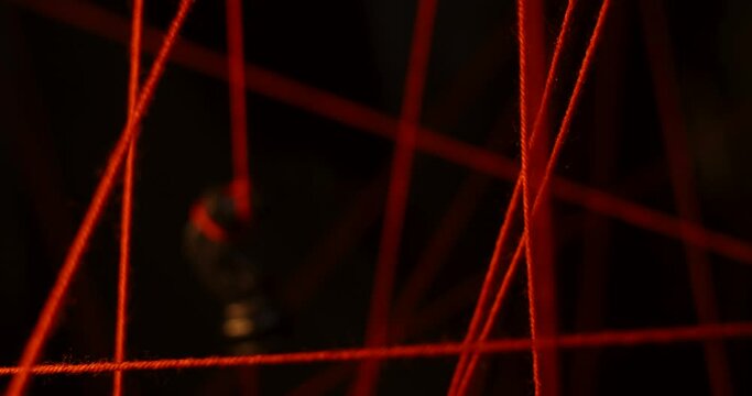 Among the stretched red threads hangs a chess piece of a black knight. Psychology and psychiatry. Visualization of phobias and their removal