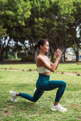 Brunette Woman Exercising in the Park on Grass