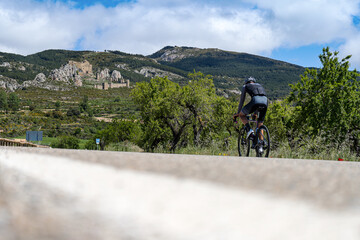 Cyclist running up to the mountain with the old medieval castle in spanish Pyrenees mountains