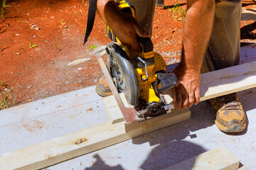 Circular saw powered by electricity is used to cut wood beams
