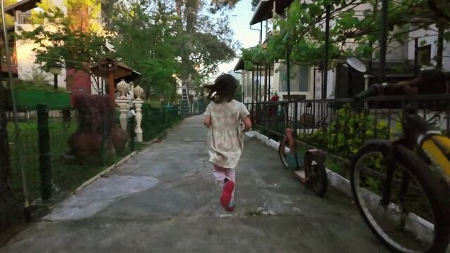 Little girl running between houses