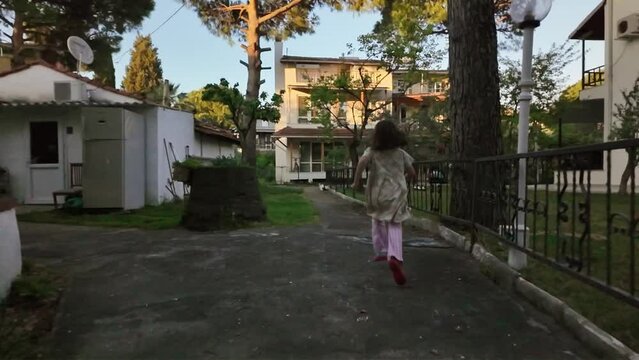 Little girl running between houses