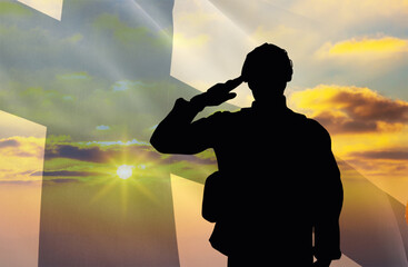 Silhouette of a soldier with a background of the Finland flag and a sunset or sunrise. Concept of national holidays. Commemoration Day.