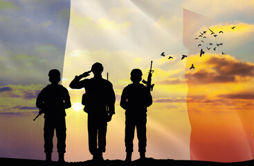 Silhouettes of soldiers with a background of the France flag and a sunset or sunrise. Concept of national holidays. Commemoration Day.