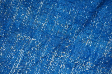 Weathered and damaged tent surface backdrop, grungy and rustic blue backdrop for presentation, cracked pattern texture background
