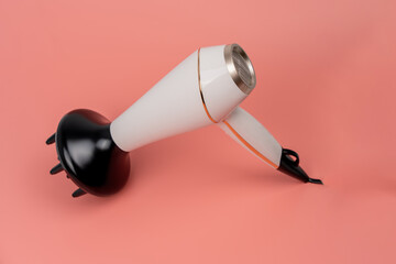 Hair dryer for drying hair on a pink background. The buttons are labeled 