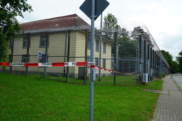 Barrier tape as a police barrier (police cordon) in front of the deportation center secured with a...