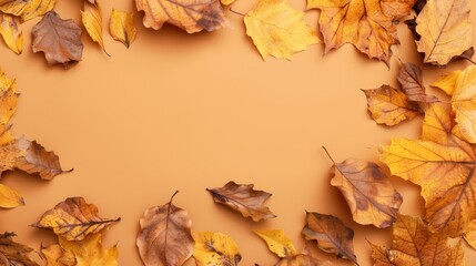 Naklejka premium Top view of yellow and brown autumn leaves on pastel brown backdrop with copy space