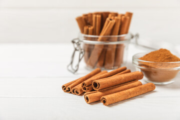 Cinnamon sticks on a textured wooden background. Cinnamon roll. Spicy spice for baking, desserts and drinks. Fragrant ground cinnamon. cinnamon powder Close-up. Place for text. copy space