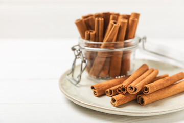 Cinnamon sticks on a textured wooden background. Cinnamon roll. Spicy spice for baking, desserts and drinks. Fragrant ground cinnamon. cinnamon powder Close-up. Place for text. copy space