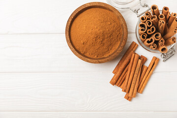 Cinnamon sticks on a textured wooden background. Cinnamon roll. Spicy spice for baking, desserts and drinks. Fragrant ground cinnamon. cinnamon powder Close-up. Place for text. copy space