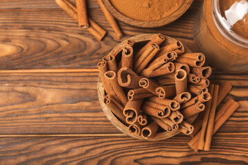 Cinnamon sticks on a textured wooden background. Cinnamon roll. Spicy spice for baking, desserts and drinks. Fragrant ground cinnamon. cinnamon powder Close-up. Place for text. copy space
