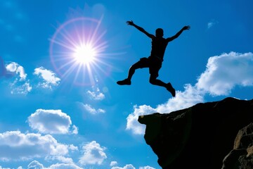 A man is jumping off a cliff into the blue sky. Concept of freedom and adventure