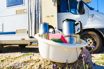 Washing dishes in bowl, capming outdoor