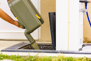 Man emptying caravan tank toilet cassette in dump station.