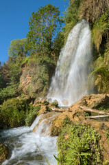 The image shows a waterfall cascading down a rocky cliff.
