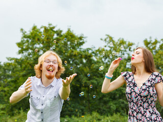 Couple blowing soap bubbles, having fun