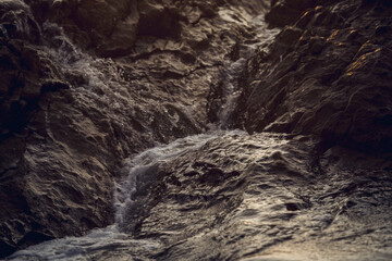 A large rocks surrounded by waves of the ocean